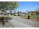 Gravel driveway leading to a single-story home, complemented by a large yard and a detached shed at 122 Blueberry Dr, Selma, NC 27576