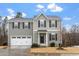 Two-story home with gray siding, black shutters, a gray roof and a white garage door at 1423 Bridgewater Dr, Durham, NC 27704