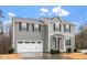 Two-story home with gray siding, black shutters, white garage door and front door at 1423 Bridgewater Dr, Durham, NC 27704