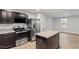 The modern kitchen boasts stainless steel appliances, dark cabinets, and island for dining at 1423 Bridgewater Dr, Durham, NC 27704