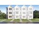 Charming exterior of a newly constructed townhome features white siding and black framed windows at 1546 Crescent Townes Way, Raleigh, NC 27604