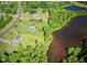 Aerial view showcasing the neighborhood, lake, and tree-lined street at 1721 Daniels Farm Rd, Mebane, NC 27302