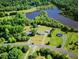 Aerial view of a home nestled among lush trees with a nearby lake at 1721 Daniels Farm Rd, Mebane, NC 27302