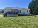 Spacious backyard featuring a wooden deck with a pergola, lush green lawn, and mature trees at 1721 Daniels Farm Rd, Mebane, NC 27302