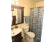 Clean bathroom with a sink, vanity, toilet, and shower featuring a patterned curtain, plus matching towel rack at 1721 Daniels Farm Rd, Mebane, NC 27302