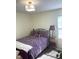 Bright bedroom with a large window, bed with purple floral bedding, and matching wooden bedside table at 1721 Daniels Farm Rd, Mebane, NC 27302