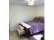 Cozy bedroom featuring a black metal bed frame, purple patterned bedding, and a neutral accent bench at 1721 Daniels Farm Rd, Mebane, NC 27302
