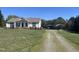Exterior view of home with a long gravel driveway leading to metal carports, and expansive lawn at 1721 Daniels Farm Rd, Mebane, NC 27302