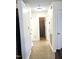 Well-lit hallway with tile flooring, leading to the bathroom, featuring white trim, and neutral walls at 1721 Daniels Farm Rd, Mebane, NC 27302