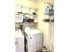 Functional laundry room with white washer and dryer units, wire shelving, and ample storage solutions at 1721 Daniels Farm Rd, Mebane, NC 27302