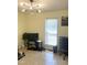 Functional living room with tile flooring, a modern chandelier, and a dedicated workspace near the window at 1721 Daniels Farm Rd, Mebane, NC 27302