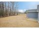 Spacious backyard with fresh seed and view of a natural treeline in the distance at 175 David Ln, Roxboro, NC 27573
