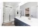 Bright bathroom with double sink vanity, glass shower, and a large mirror at 175 David Ln, Roxboro, NC 27573