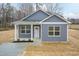 Charming single-story home featuring a light gray exterior and well-manicured front lawn with an inviting front porch at 175 David Ln, Roxboro, NC 27573