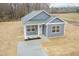 New single-story home features light gray siding, green roof, tidy landscaping, and a front porch at 175 David Ln, Roxboro, NC 27573
