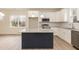 Well-appointed kitchen with white cabinetry, granite countertops, stainless steel appliances, and a navy blue island at 175 David Ln, Roxboro, NC 27573