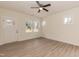 Modern living room with large windows, a ceiling fan, and light wood-look flooring at 175 David Ln, Roxboro, NC 27573