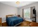 The bedroom has hardwood floors, natural light from the windows, and a mounted television at 1808 Pattersons Mill Rd, Durham, NC 27703