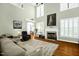 Bright living room with a fireplace, tall windows, hardwood floors, and comfortable seating at 1808 Pattersons Mill Rd, Durham, NC 27703