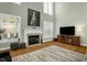 Cozy living room features a fireplace, large windows, and hardwood floors at 1808 Pattersons Mill Rd, Durham, NC 27703