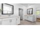 Bright bathroom featuring double sink vanity, white cabinets, framed mirrors, and a view to the bedroom at 1914 Malvina Ct, Graham, NC 27253