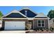 Charming single-Gathering home featuring stone and blue siding, a two-car garage, and a well-manicured lawn at 1914 Malvina Ct, Graham, NC 27253