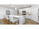 Kitchen with a quartz island with seating, white cabinets, and stainless steel appliances at 1914 Malvina Ct, Graham, NC 27253