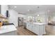 Bright kitchen features white cabinets, stainless steel appliances, quartz countertops, and wood grain tile flooring at 1914 Malvina Ct, Graham, NC 27253