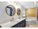 Elegant bathroom with double vanity, framed mirrors, soaking tub, and refined finishes at 198 Hillsdale Dr, Archer Lodge, NC 27527