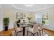 Bright dining room boasts elegant wainscoting, modern light fixture, and a glass table with seating for six at 198 Hillsdale Dr, Archer Lodge, NC 27527