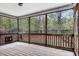 Inviting screened porch with wood flooring and railings offering views of the surrounding trees at 198 Hillsdale Dr, Archer Lodge, NC 27527