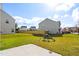 Large, level backyard with green grass, patio, and view of the neighborhood at 2 Bolter Ct, Durham, NC 27704