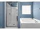 Bathroom with large tub, glass shower, and blue walls at 2 Bolter Ct, Durham, NC 27704