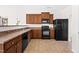 Compact kitchen featuring dark wood cabinets, black appliances, and a pass-through to another space at 2 Bolter Ct, Durham, NC 27704