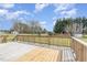 Wooden deck with a railing overlooks the backyard with lush greenery at 201 Alice Dr, Garner, NC 27529