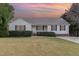Classic house with a cozy front porch, blue shutters, and a well-kept lawn under a colorful sky at 201 Alice Dr, Garner, NC 27529
