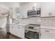 Close up of stainless steel appliances and white cabinetry in the renovated kitchen at 201 Alice Dr, Garner, NC 27529