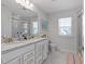 Bright bathroom featuring double vanity, granite countertops, and tile flooring, exuding a clean and modern aesthetic at 2040 Water Marsh Trl, Fuquay Varina, NC 27526