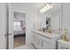 Well-lit bathroom with double sinks, granite counters, and an open doorway revealing a cozy bedroom at 2040 Water Marsh Trl, Fuquay Varina, NC 27526