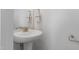 Elegant half-bathroom with pedestal sink, decorative mirror, and towel rack at 2040 Water Marsh Trl, Fuquay Varina, NC 27526