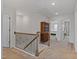 A charming hallway with decorative railings and a view into the bedrooms featuring plush carpeting at 2040 Water Marsh Trl, Fuquay Varina, NC 27526
