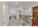 A bright upstairs hallway leading to a living area showcasing neutral carpeting and convenient layout at 2040 Water Marsh Trl, Fuquay Varina, NC 27526