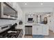 Open-concept kitchen featuring stainless appliances, white cabinets, and quartz countertops at 2040 Water Marsh Trl, Fuquay Varina, NC 27526