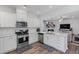 Modern kitchen with stainless steel appliances, white cabinets, and open living space at 2040 Water Marsh Trl, Fuquay Varina, NC 27526