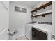 Efficient laundry room featuring a modern washer and dryer, complemented by stylish shelving at 2040 Water Marsh Trl, Fuquay Varina, NC 27526