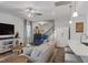 Bright living room with ceiling fan, wooden floors and adjacent kitchen and stairway at 2040 Water Marsh Trl, Fuquay Varina, NC 27526