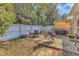 Backyard featuring a mix of stone and wood patio, white fence, and patio furniture at 2043 White Pond Ct, Apex, NC 27523