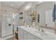 Bright bathroom features a dual sink vanity, decorative mirrors, and a glass enclosed shower at 2043 White Pond Ct, Apex, NC 27523