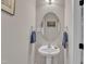 This half-bathroom features a pedestal sink, oval mirror, and modern towel racks at 2043 White Pond Ct, Apex, NC 27523