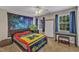 This bedroom features a ceiling fan, two windows, and a colorful galaxy tapestry at 2043 White Pond Ct, Apex, NC 27523